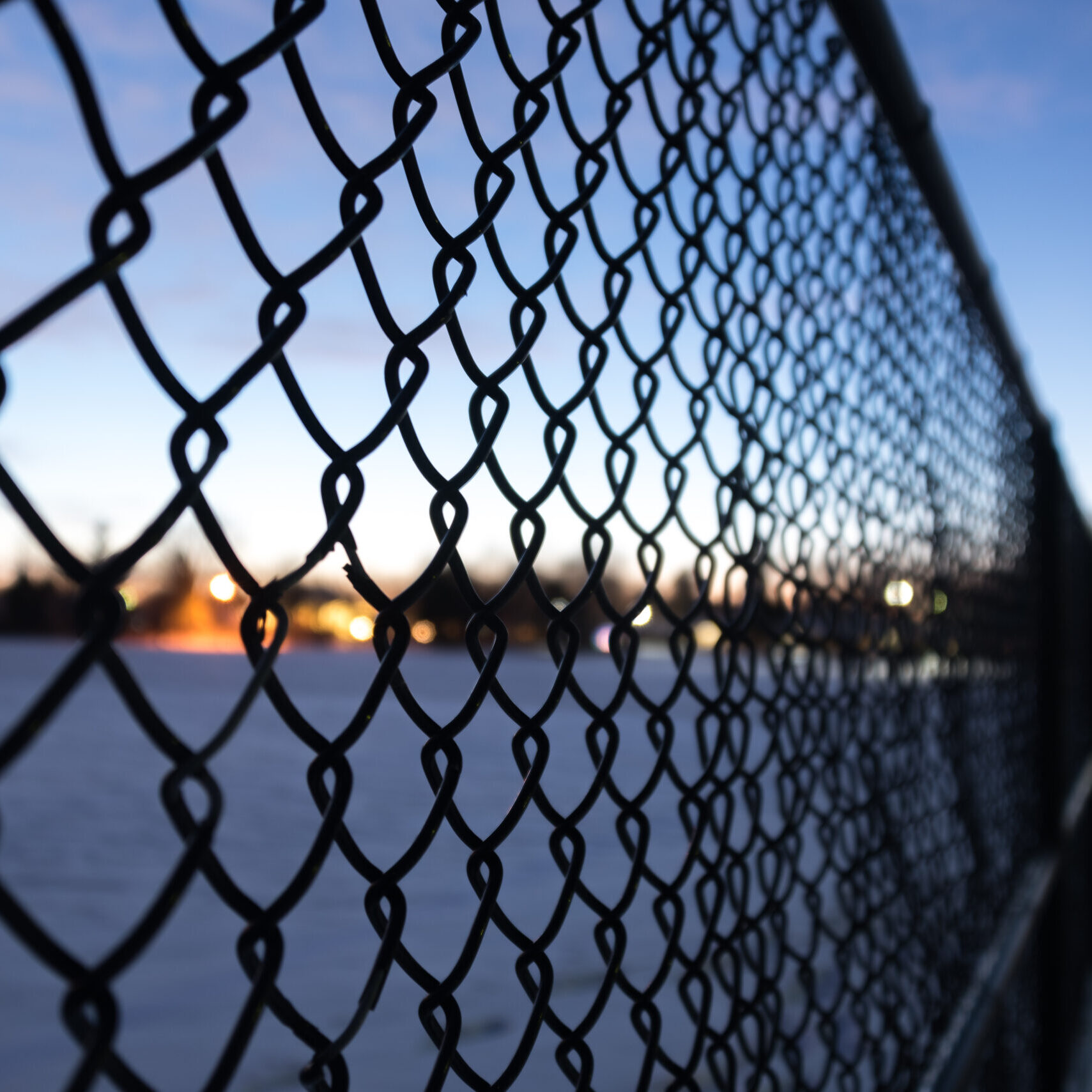 Blurry metal fence in the suburban park on a winter day